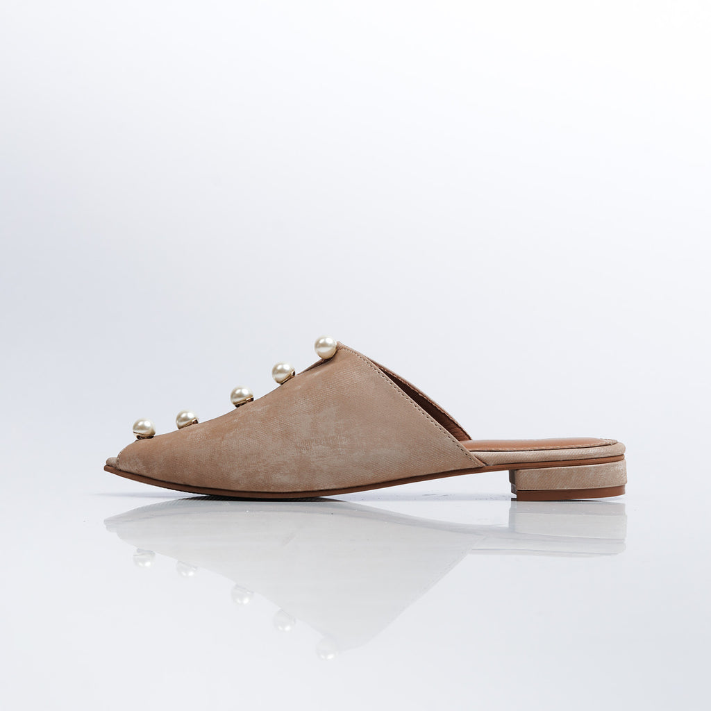 Beige mules with pearl embellishments on a white background
